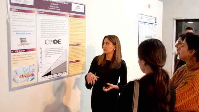 A student shares her poster presentation at FPU's Seventh Bi-Annual Graduate Research Symposium