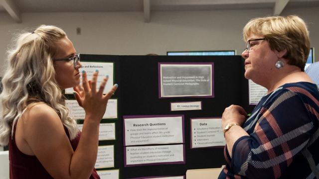 Lyndsie Clevenger, left, discusses her graduate research project with Linda Hoff, Ph.D., head of the FPU Teacher Education Divison