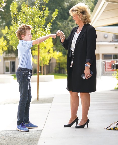 Judi fist bumps a kid