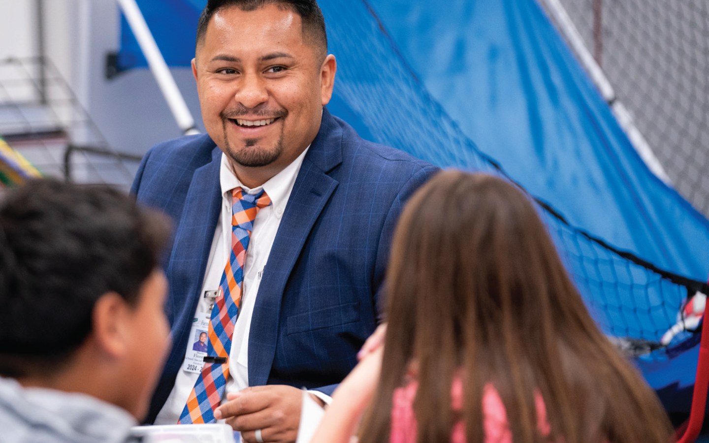 Mario Flores speaking to two kids at a table