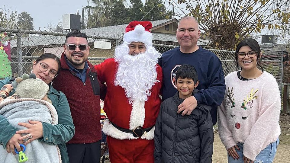 Pictured (left to right): MSW student Stacey Guzman and child; Eddie Valero, Tulare County Supervisor; MSW student Mario Flores as Santa; Saul Salinas; Matias Salinas; and MSW student Kelly Rodriguez.