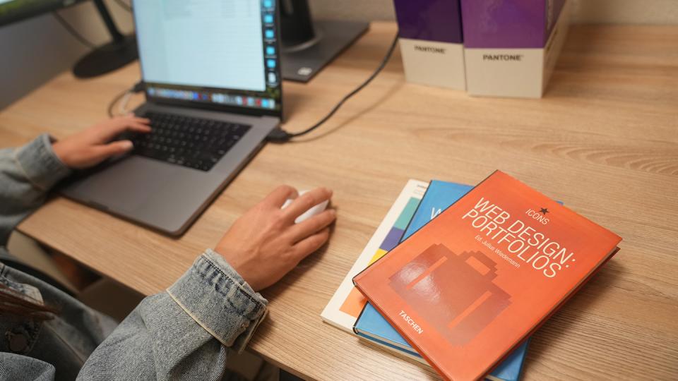 A graphic design student works on the computer