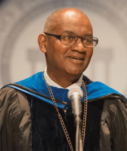 President Joseph Jones in regalia speaks at microphone for convocation