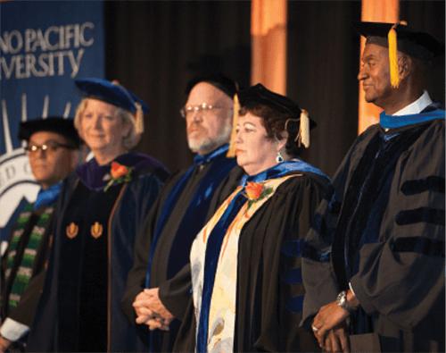 Faculty in regalia join Dr. Jones on stage