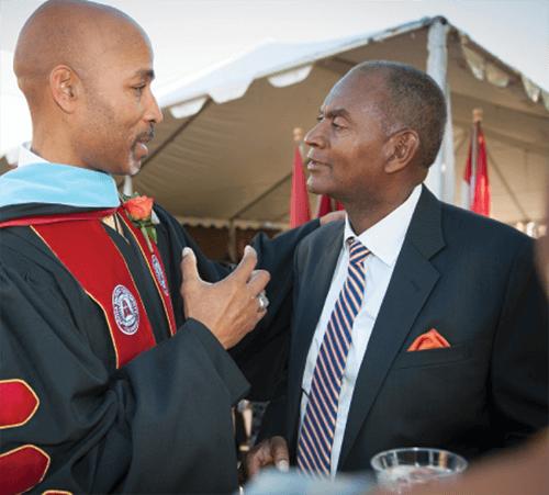 Dr. Jones congratulated by faculty member in regalia