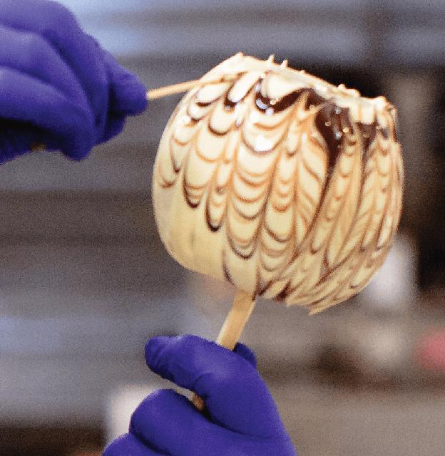 Stafford's Chocolates employee using toothpick to make designs in chocolate