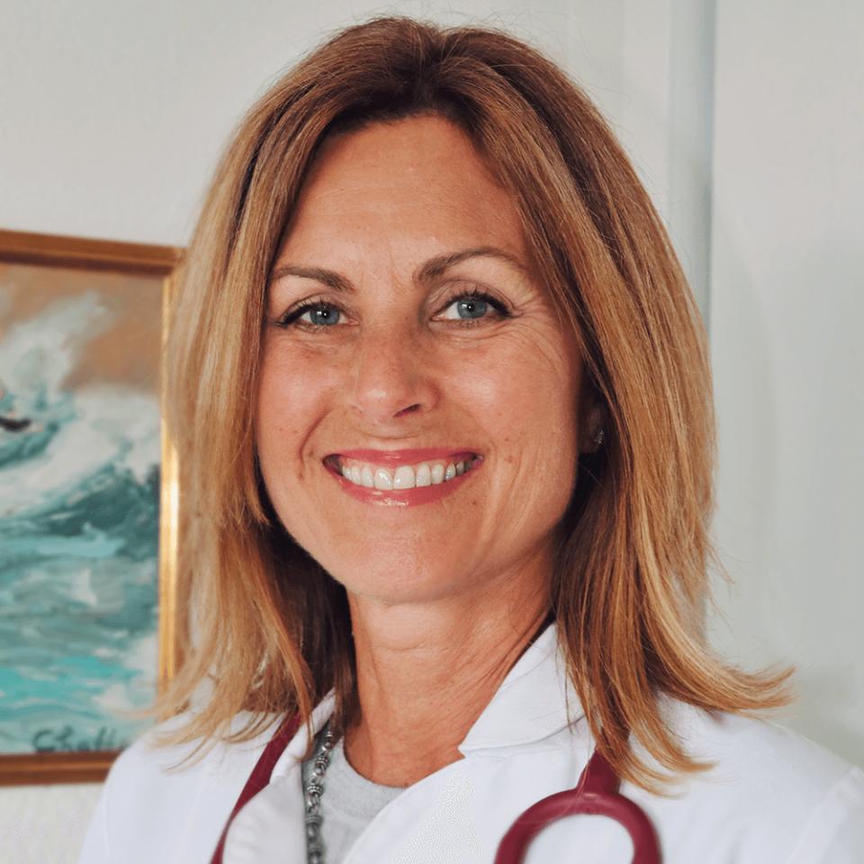 Christine Burg portrait in office wearing scrubs and stethoscope