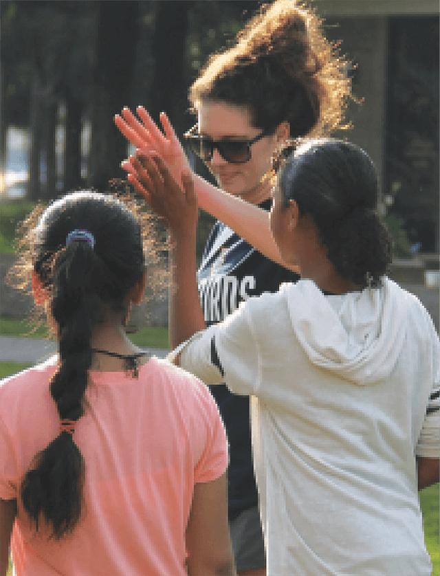 Megan Lee high-fiving child