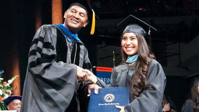Fresno Pacific University President Joseph Jones, Ph.D., stands with a new graduate in 2018