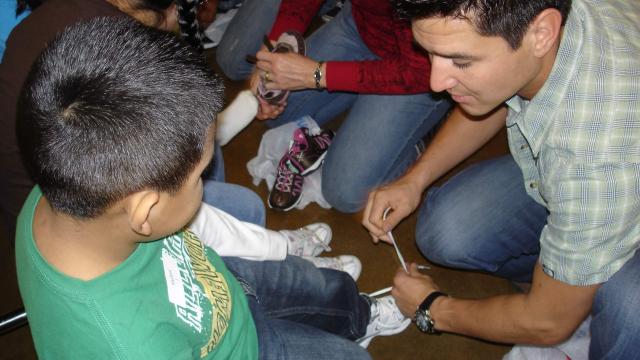 Volunteers present Valley children with new shoes