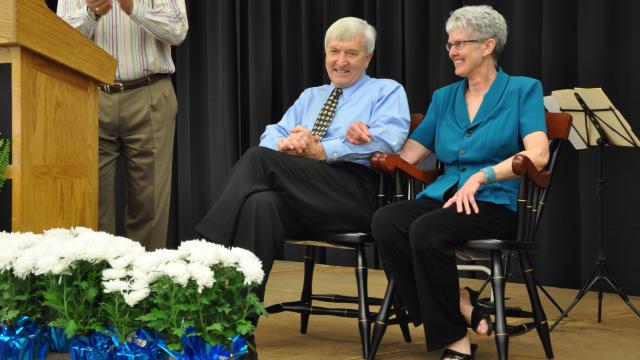 Merrill and Priscilla Ewert sit on stage as FPU says goodbye
