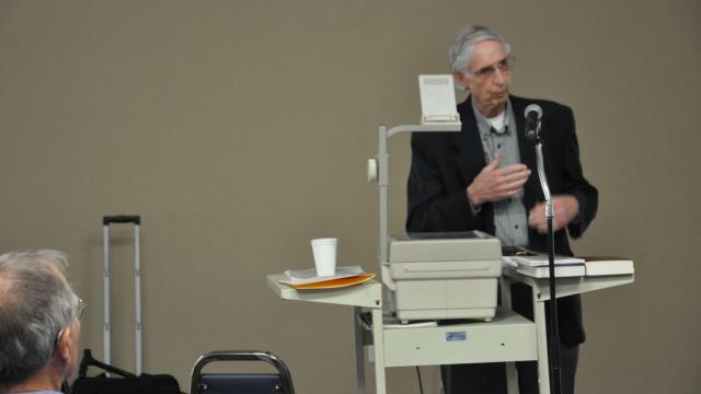 John E. Toews speaks at projector