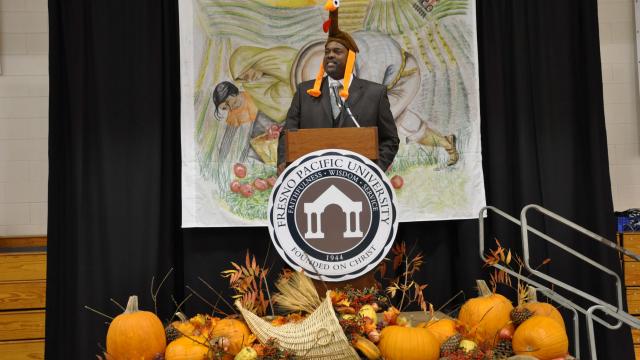 Pastor Angelus gives Thanksgiving address while wearing turkey as hat