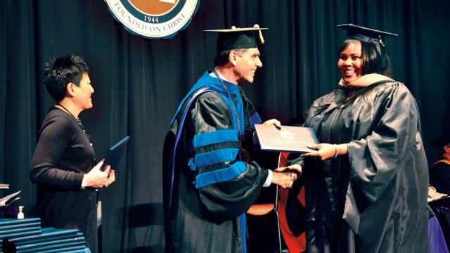 President Kriegbaum presents diploma to graduate