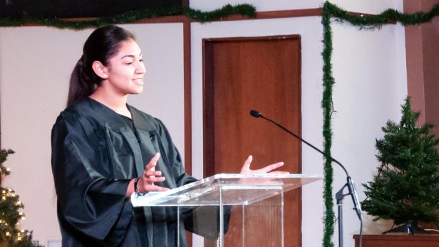 New graduate Viviana Vasquez speaks in the Butler Church sanctuary during FPU's Muticultural Baccalaureate