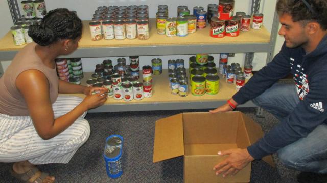 From left: Cheyenne Cade, senior, and Enzo Peraggine, sophomore, prepare food boxes at Sunbird Pantry before distributing to students.