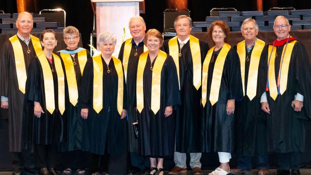 Photo of Golden Grads at commencement (back row, from left): Walter Wall, Pat (Friesen) Unruh, Ron Brown, Charles Spencer, Mark Franz and Garry Prieb. Front row, from left: Lori (Duerksen) Wall, Karen (Newfield) Peters, Judy (Dick) Brown and Susanne Penner Franz.