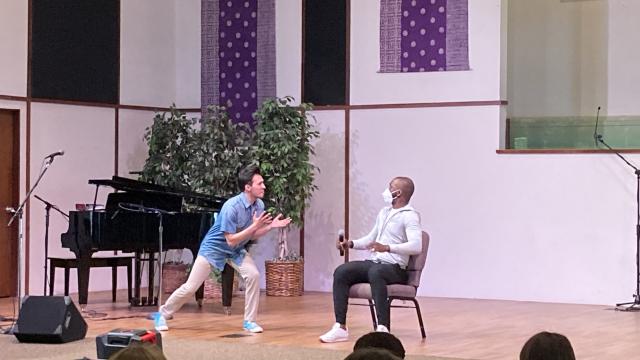 FPU student Alexander Lujan (left) strikes a dramatic pose while portraying Donkey from the musical Shrek, singing to Christopher Scott Young (seated). 
