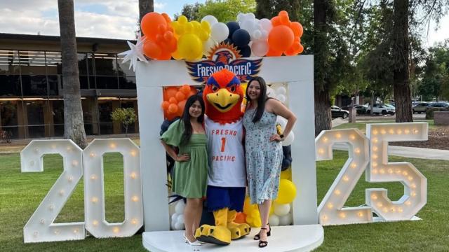 Seniors Angela Alvarado and Michelle Salazar celebrate with Sunny the Sunbird at the First to Fly gathering.