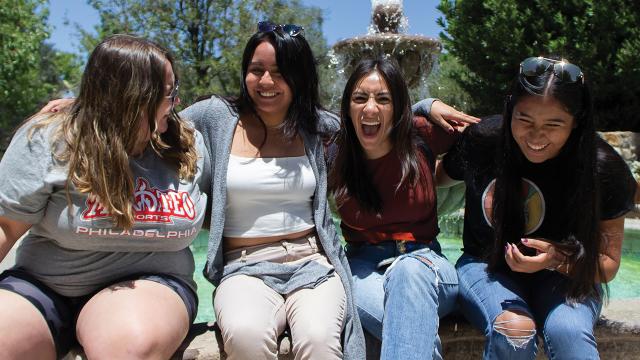 Alecia Espinosa, Karina Morales, Sarai Uriostegui and Betsy Olvera, participants in the Multicultural Peace Collaboration learning tour, smile and laugh with joy at the fountain that is part of the Cesar E. Chavez National Monument. (MCC photo/Jessica Chisolm).