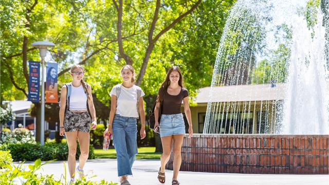 FPU students walk in front of a fountain.