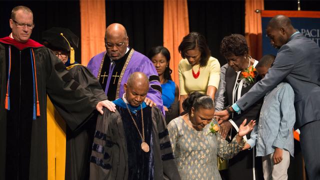 Joseph and Yvette Jones, kneeling, are prayed over by (from left) Gary Wall, Valerie Rempel, Paul Binion and members of Jones' family