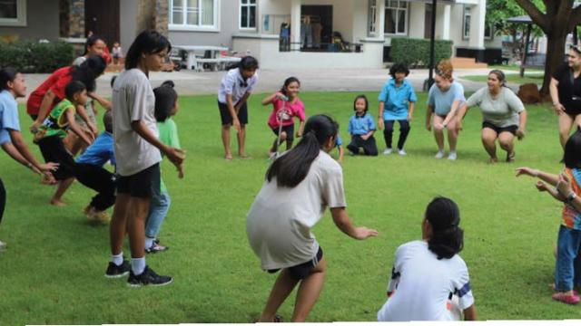 Photo of children playing a game on a field.