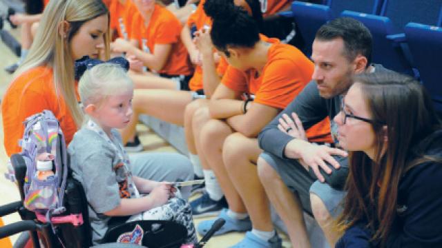 Norah Kerr sitting with the women's basketball team