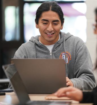 Smiling male fpu student on his laptop