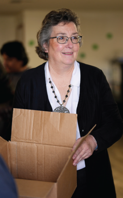 Monika Grasley folding a cardboard box