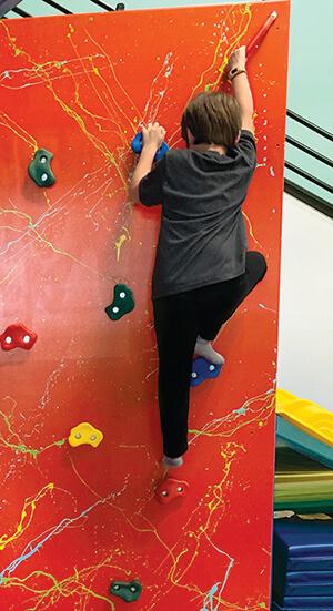 Child climbing on rock wall