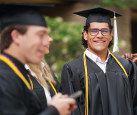 Photo of a graduating student staring at another one staring at his phone